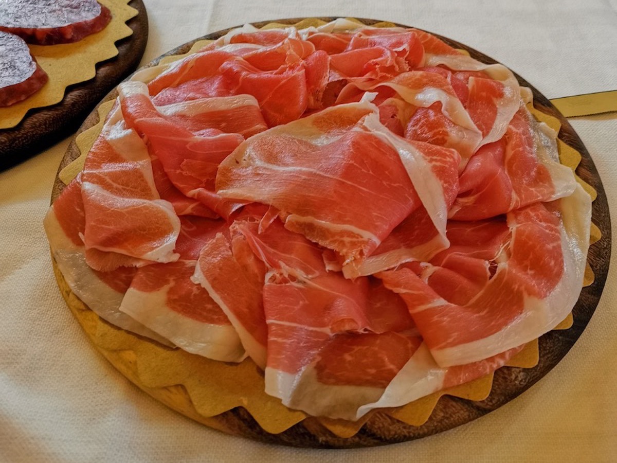 Thin slices of prosciutto arranged on a wooden board